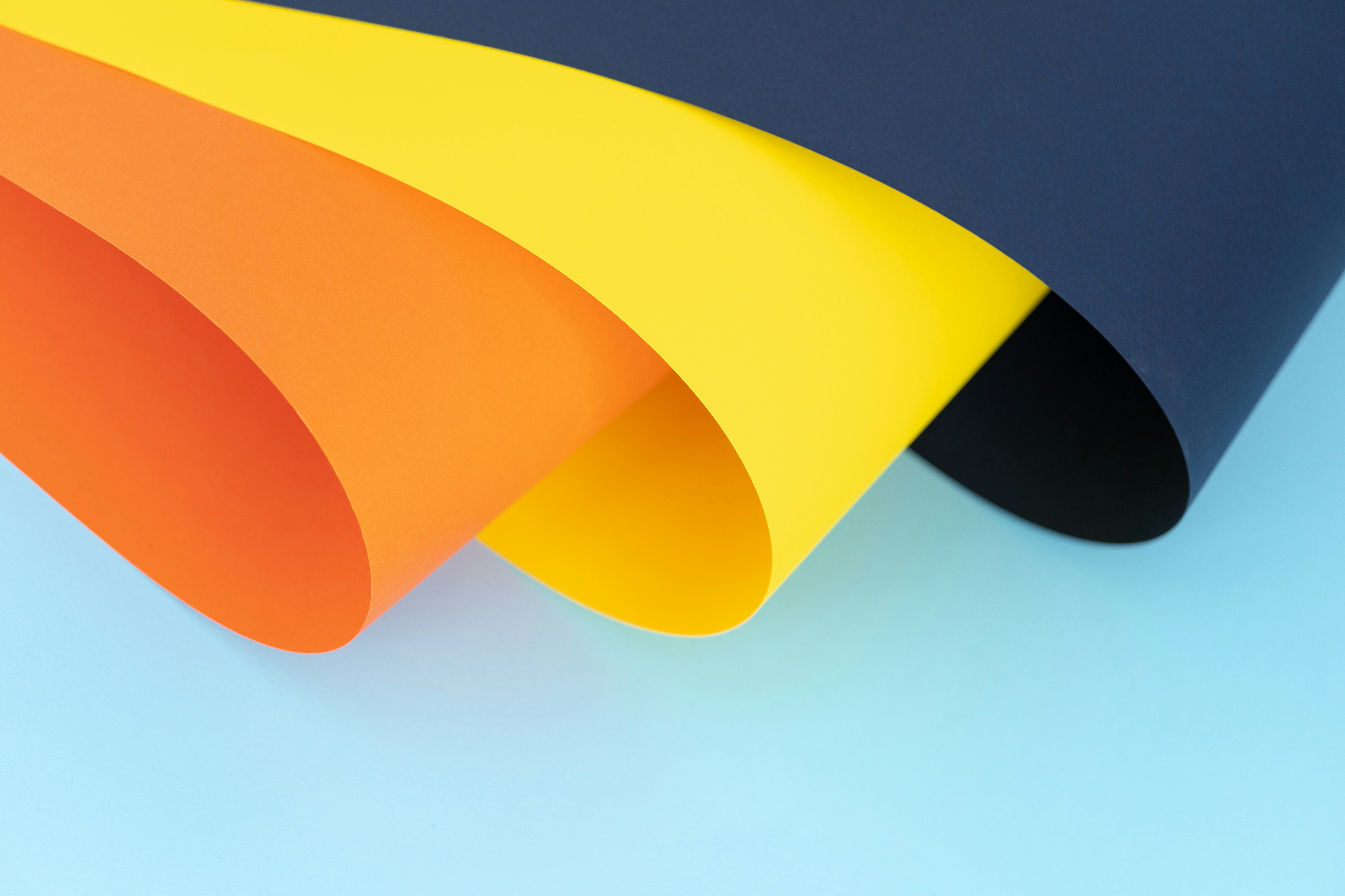 3 pieces of large poster board folded gently over. 1 is orange, one yellow, and 1 blue