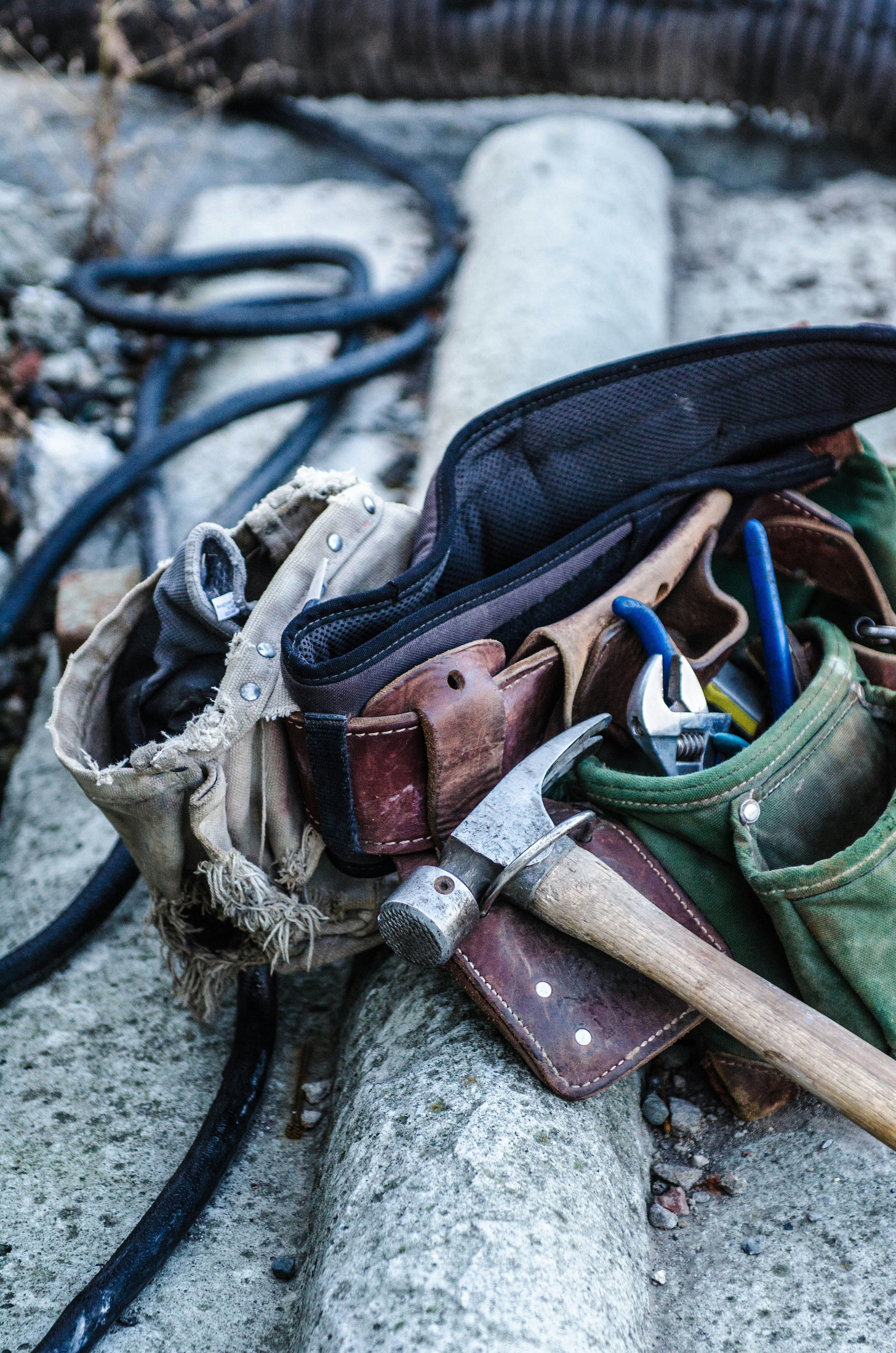 tool belt with hammer laying on the ground