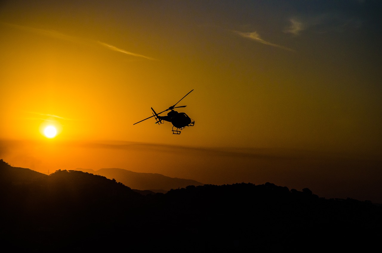 helicopter flying at sunset