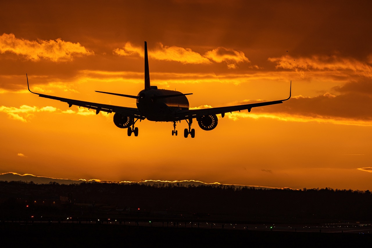 large passenger jet landing at sunset