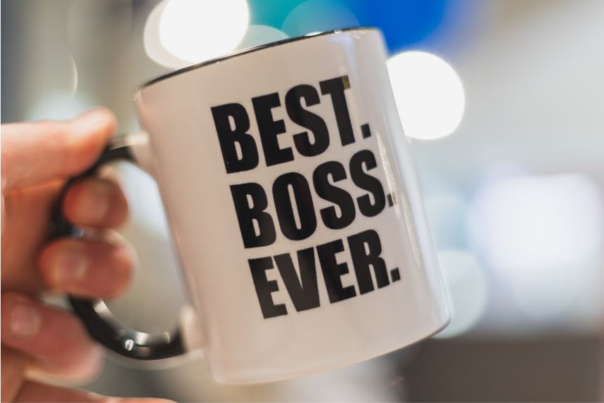 person holding coffee mug that reads best boss ever