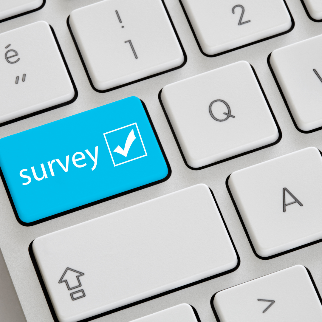 mac keyboard with a blue key labelled survey