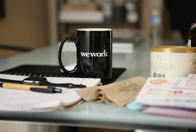 desk top with notebook, apple watch, pen, coffee mug, etc. on it