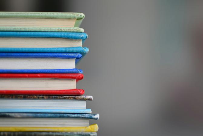 a stack of multi coloured school books