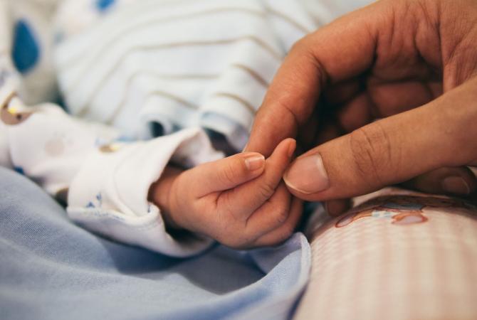 adult hand holding fingers of tiny baby. health, health care, nurse, doctor, hospitals